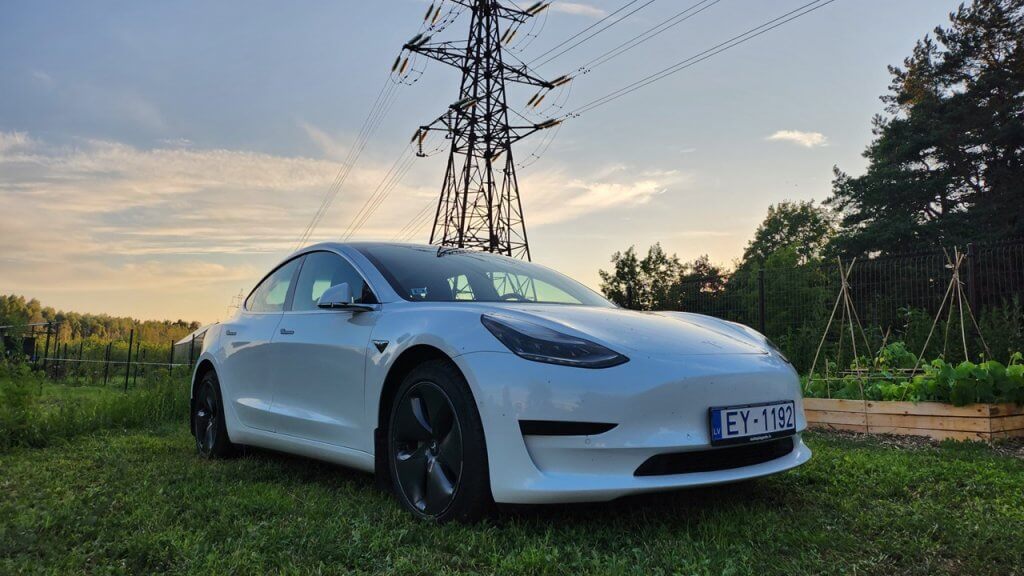 Tesla Model 3 at sunset with electric lines in background