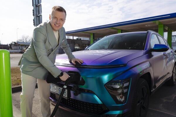 Krišjānis Caune pie sacīkšu Hyundai Kona un Neste uzlādes stacijas